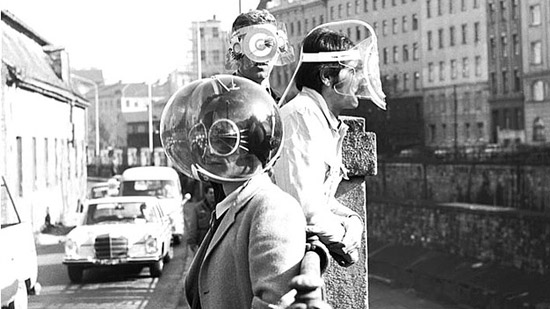 People wearing masks and spheres over their heads to obscure or shift their senses