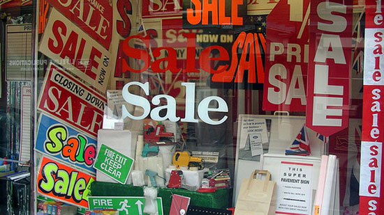 A storefront display full of various SALE signs