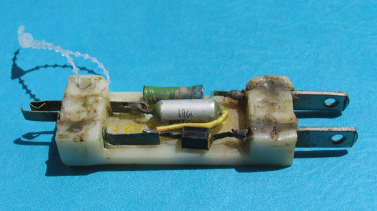 An electrical plug broken open to reveal its components