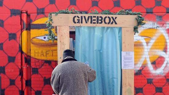 A man putting something into a donation box