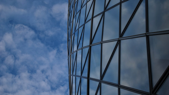 Photograph of a glass facade and a blue sky