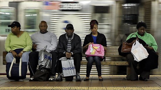 Subway commuters sitting on a bench in a train station