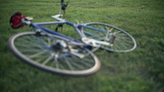 Bicycle laying down in a field of grass